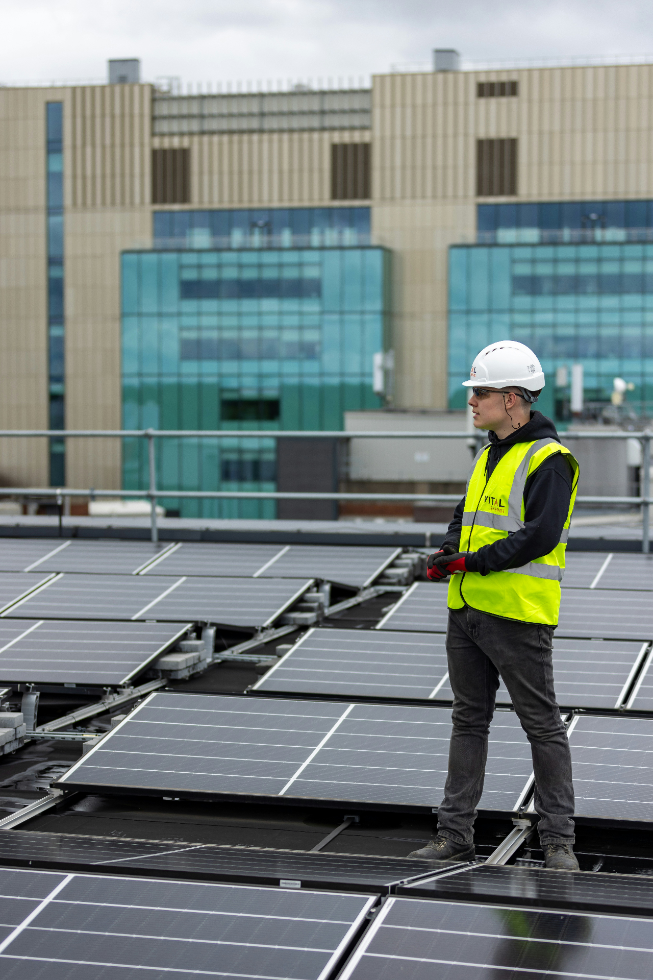 Inženjer u reflektirajućem prsluku pregledava solarne panele